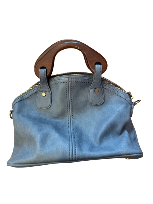 Blue handbag with wooden handle on a wooden surface